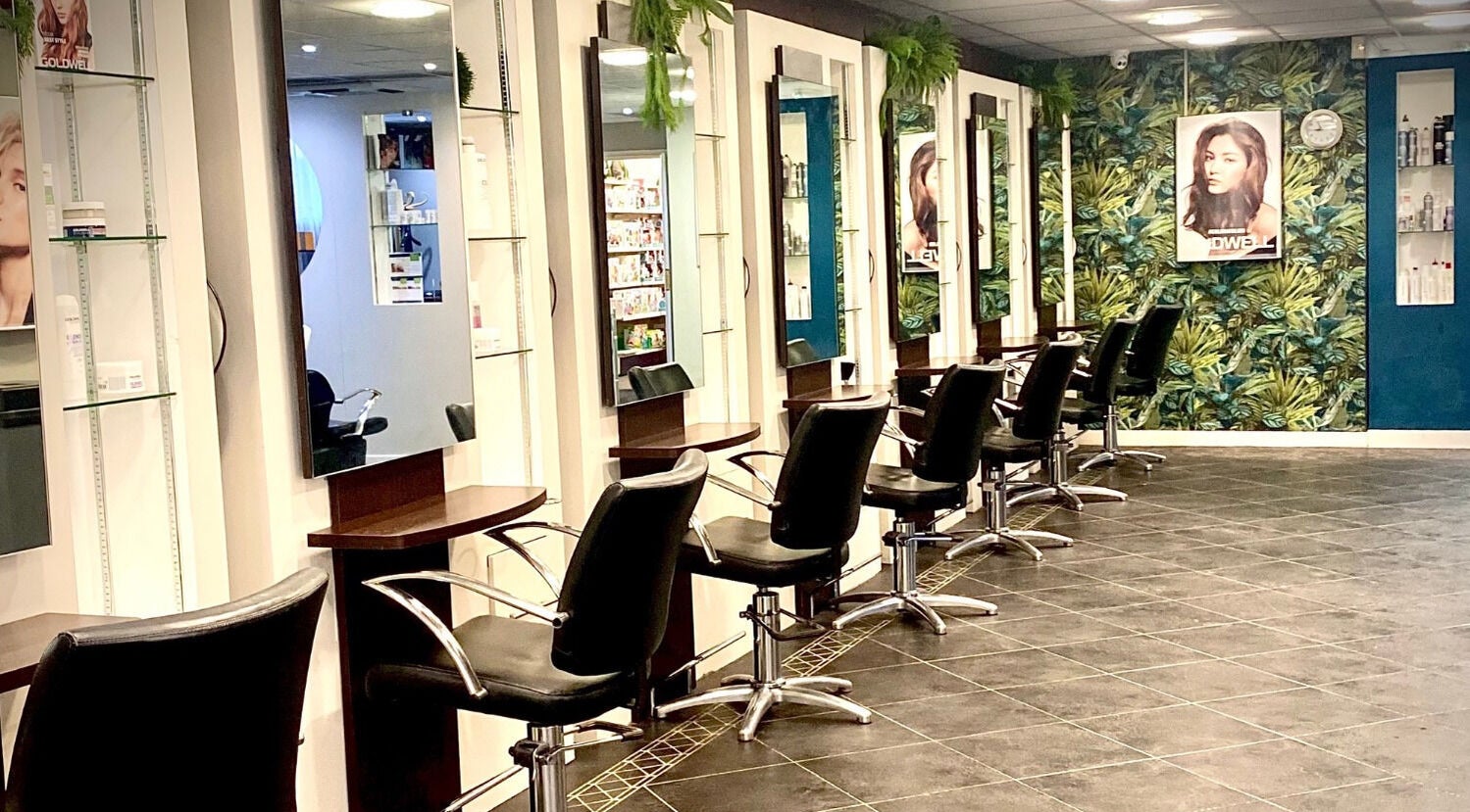 Modern salon interior at hairstyles@wetherells, Selby, England, GB with sleek chairs and vibrant decor.