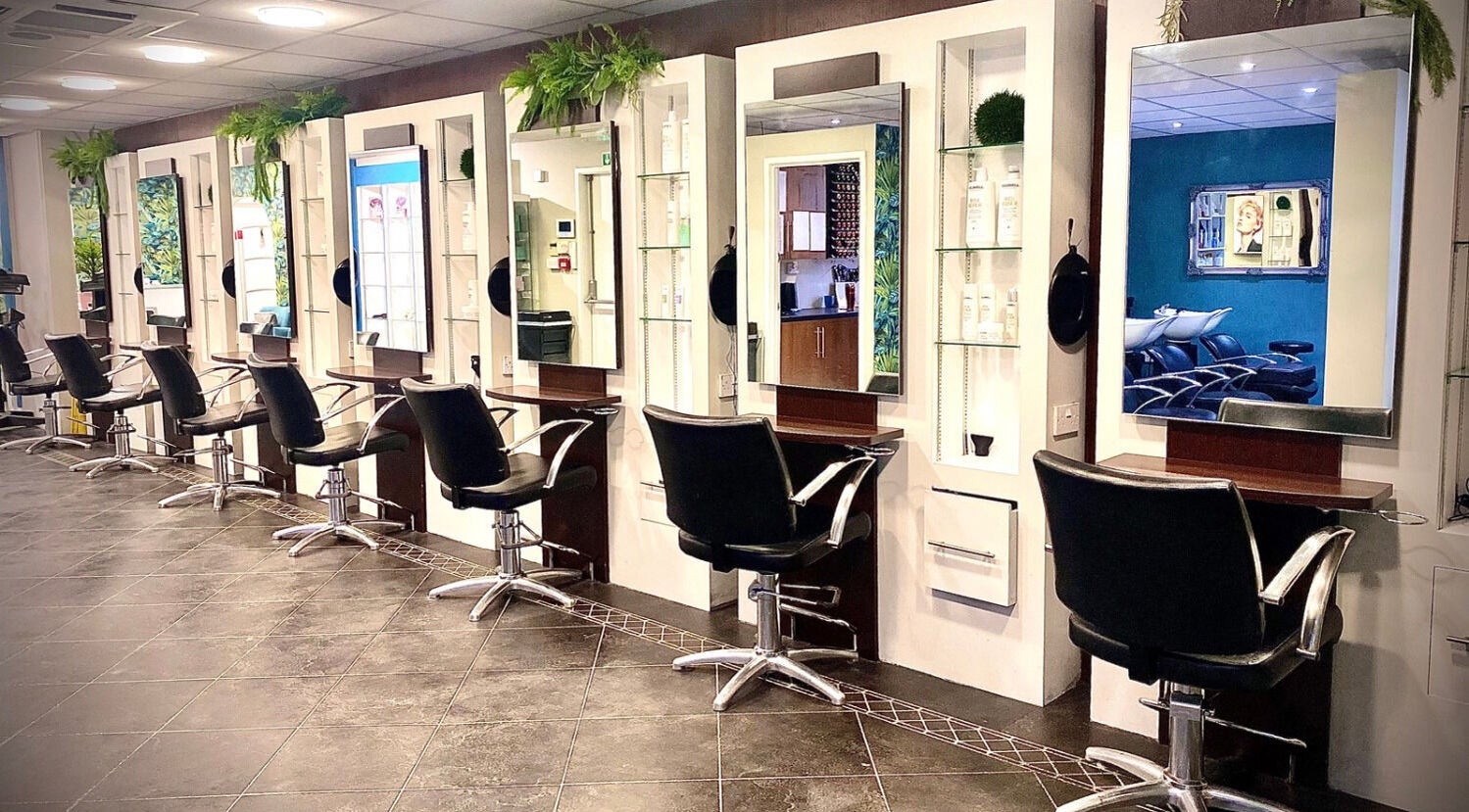 Modern salon interiors at hairstyles@wetherells in Selby, England, GB with stylish workstations and mirrors.