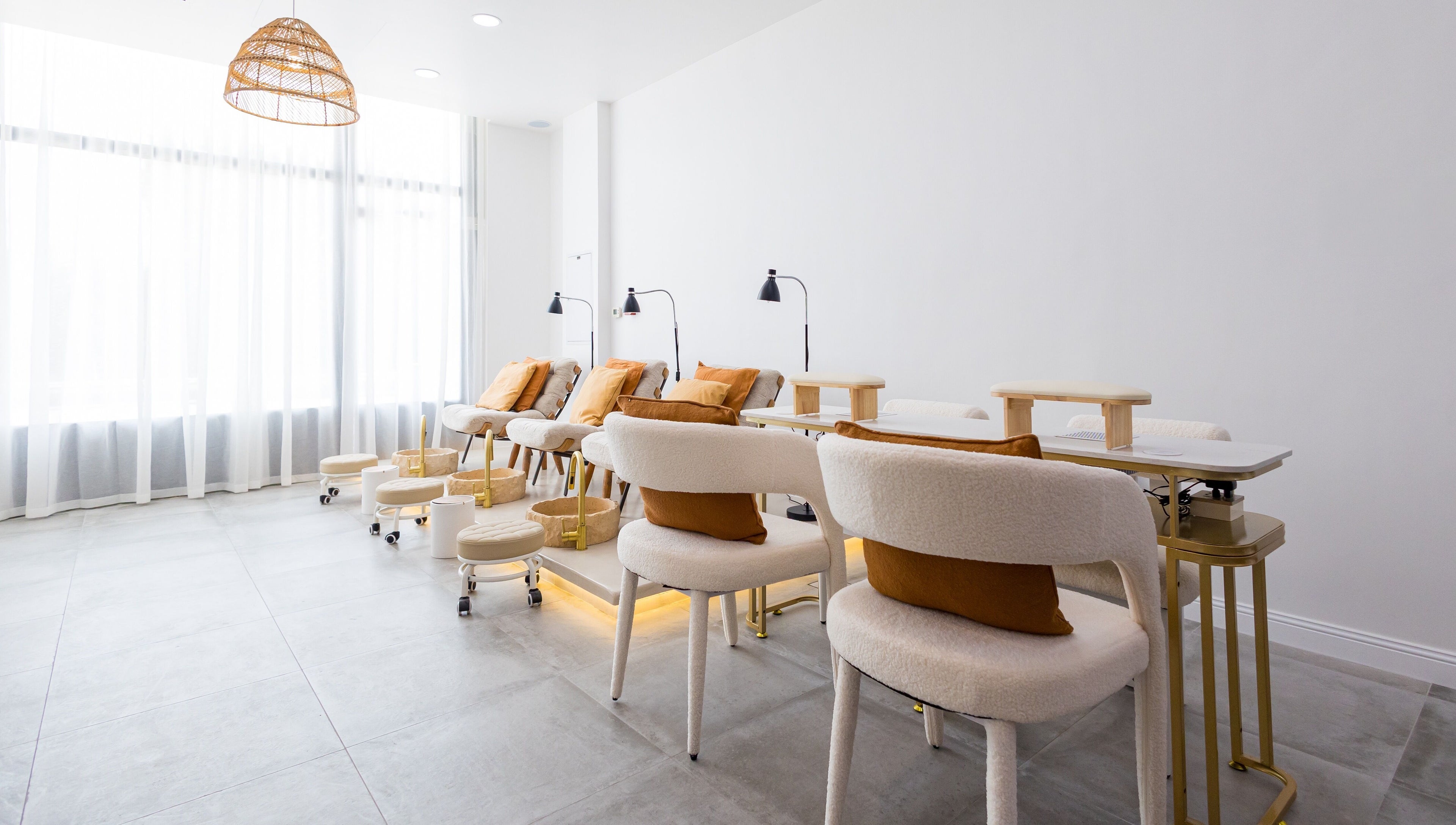Modern and serene nail area at The Den Salon in Dubai, AE with plush seating and ambient lighting.