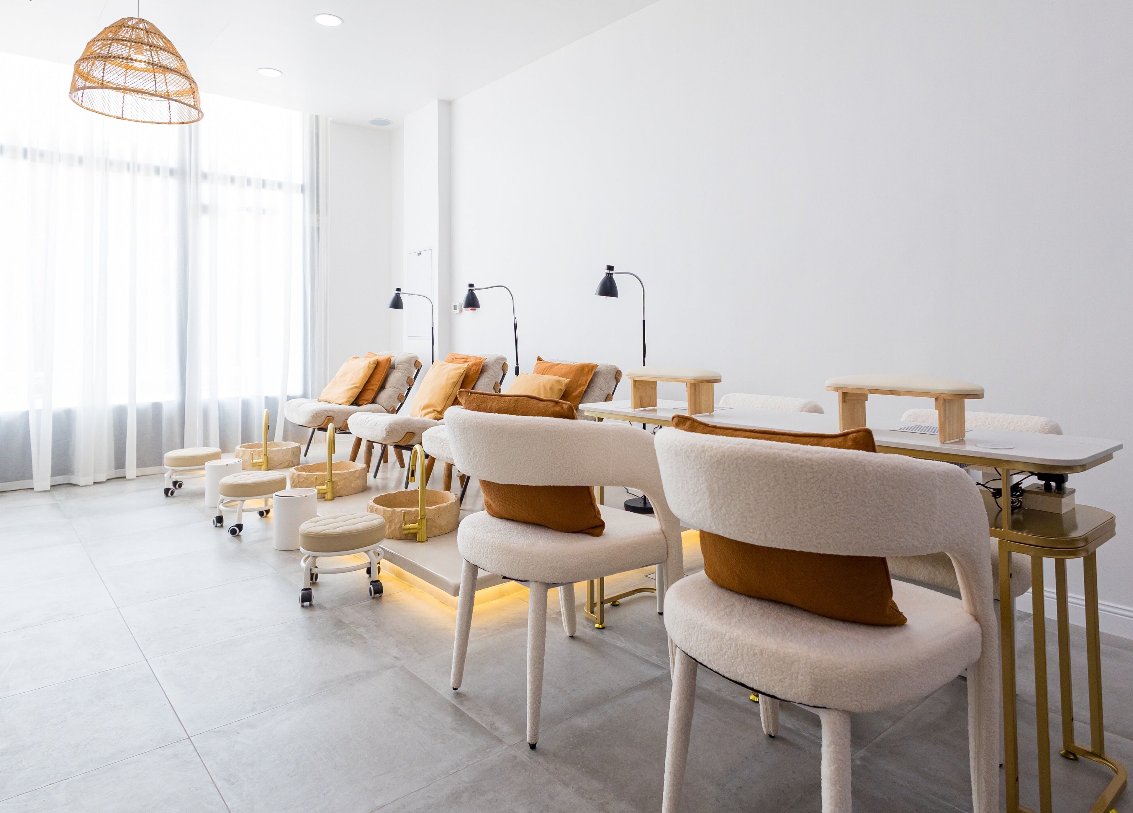 Modern and serene nail area at The Den Salon in Dubai, AE with plush seating and ambient lighting.