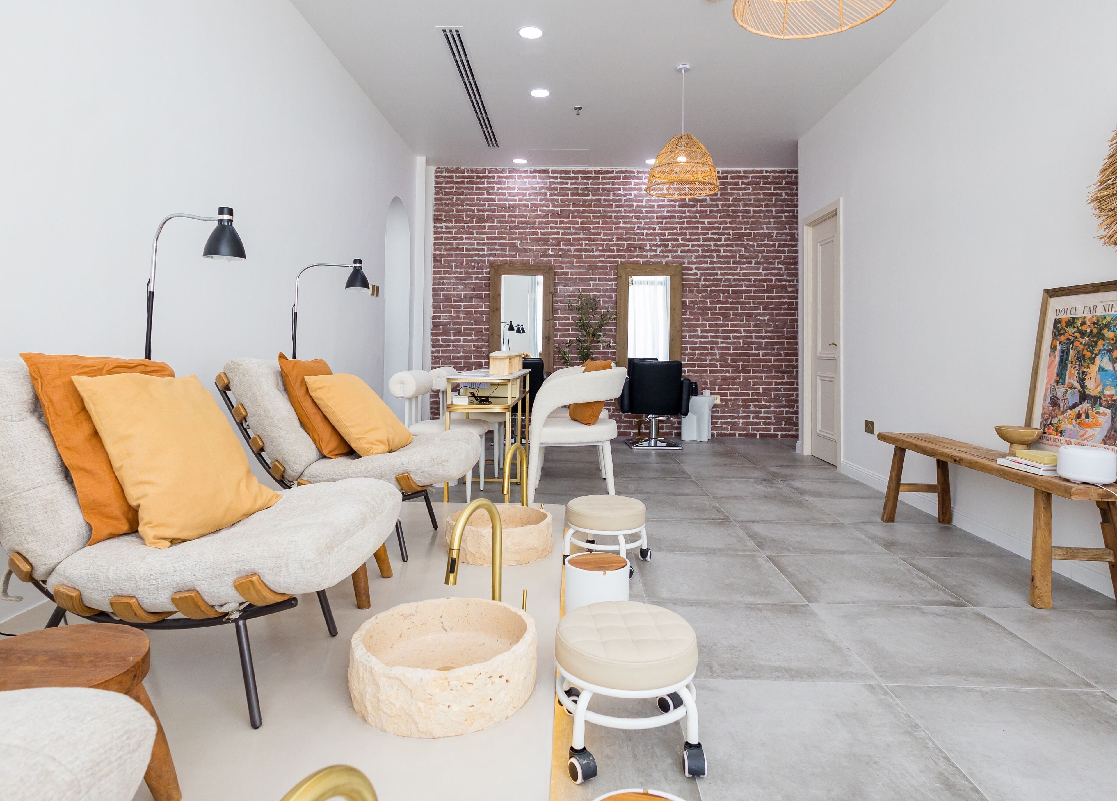 Relaxing seating area at The Den Salon, Dubai, AE, features comfortable chairs and elegant decor.