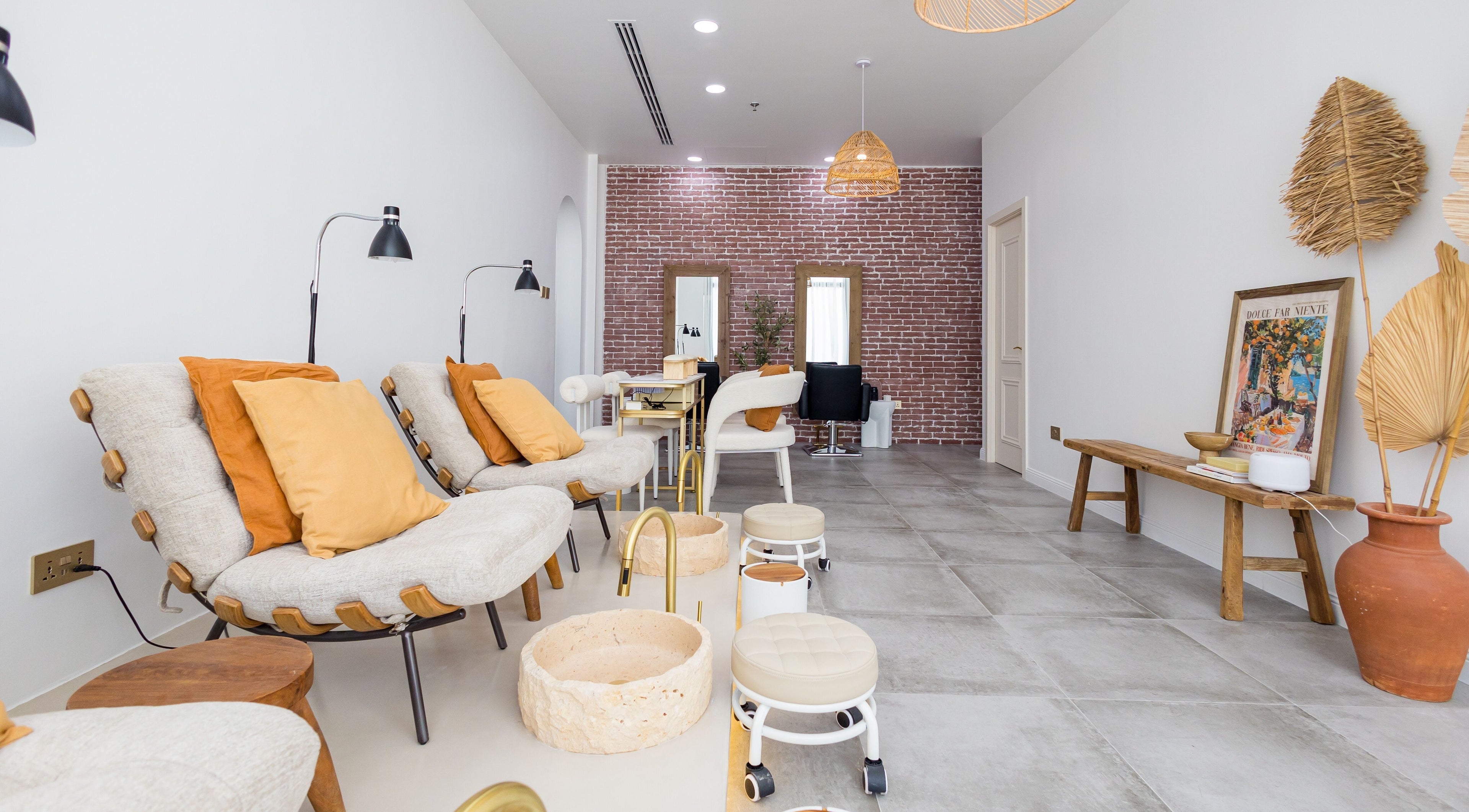Relaxing seating area at The Den Salon, Dubai, AE, features comfortable chairs and elegant decor.