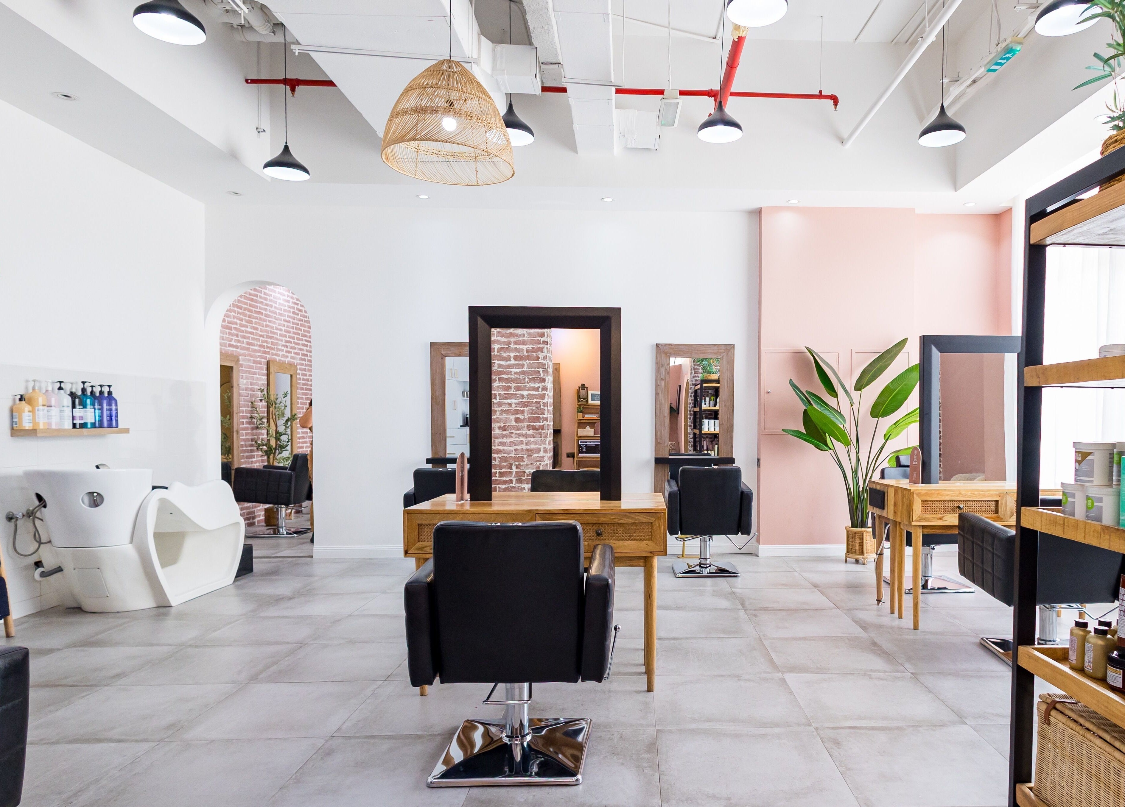 Interior of The Den Salon in Dubai, AE, showcasing modern chairs, mirrors, and well-organized shelves.