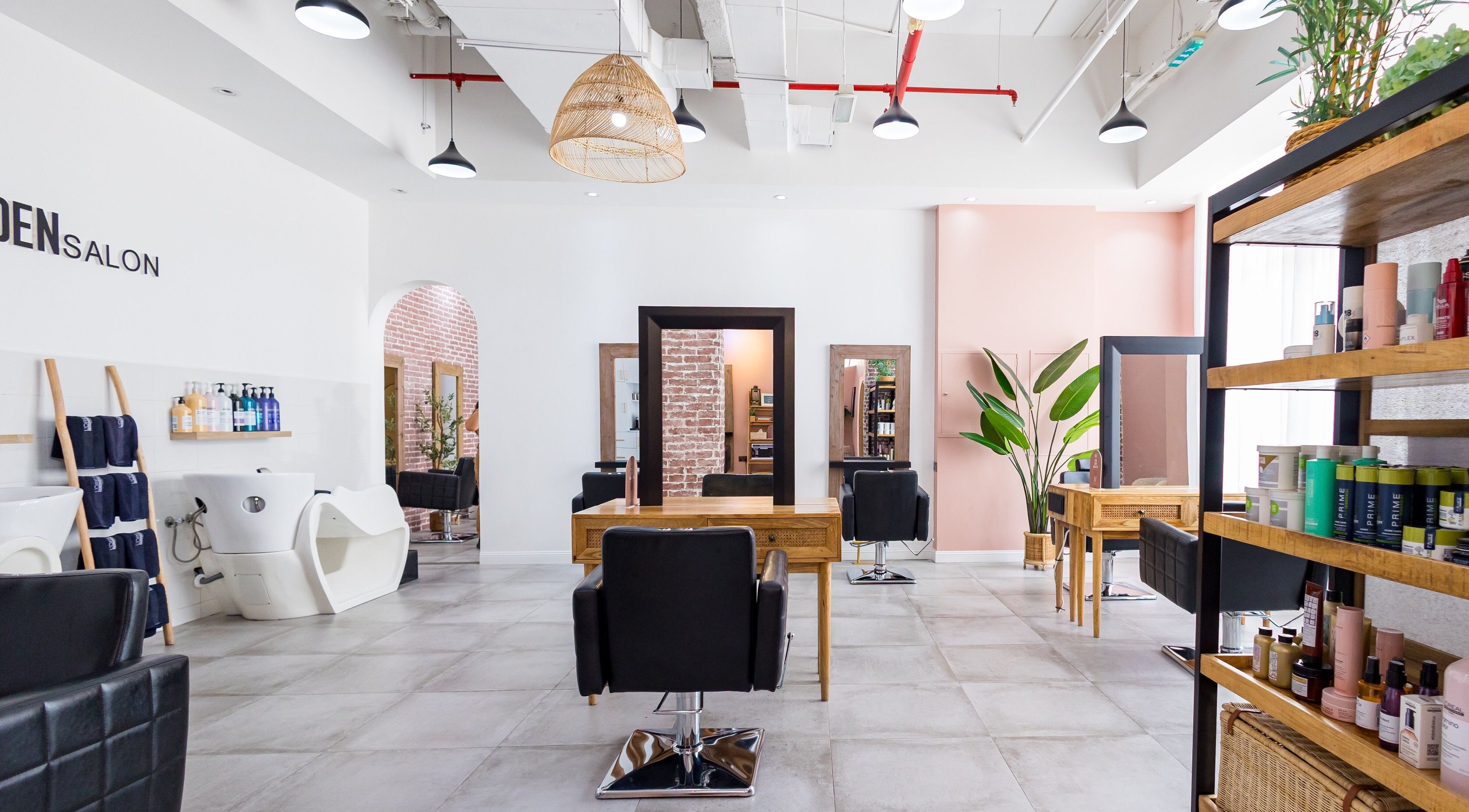 Interior of The Den Salon in Dubai, AE, showcasing modern chairs, mirrors, and well-organized shelves.