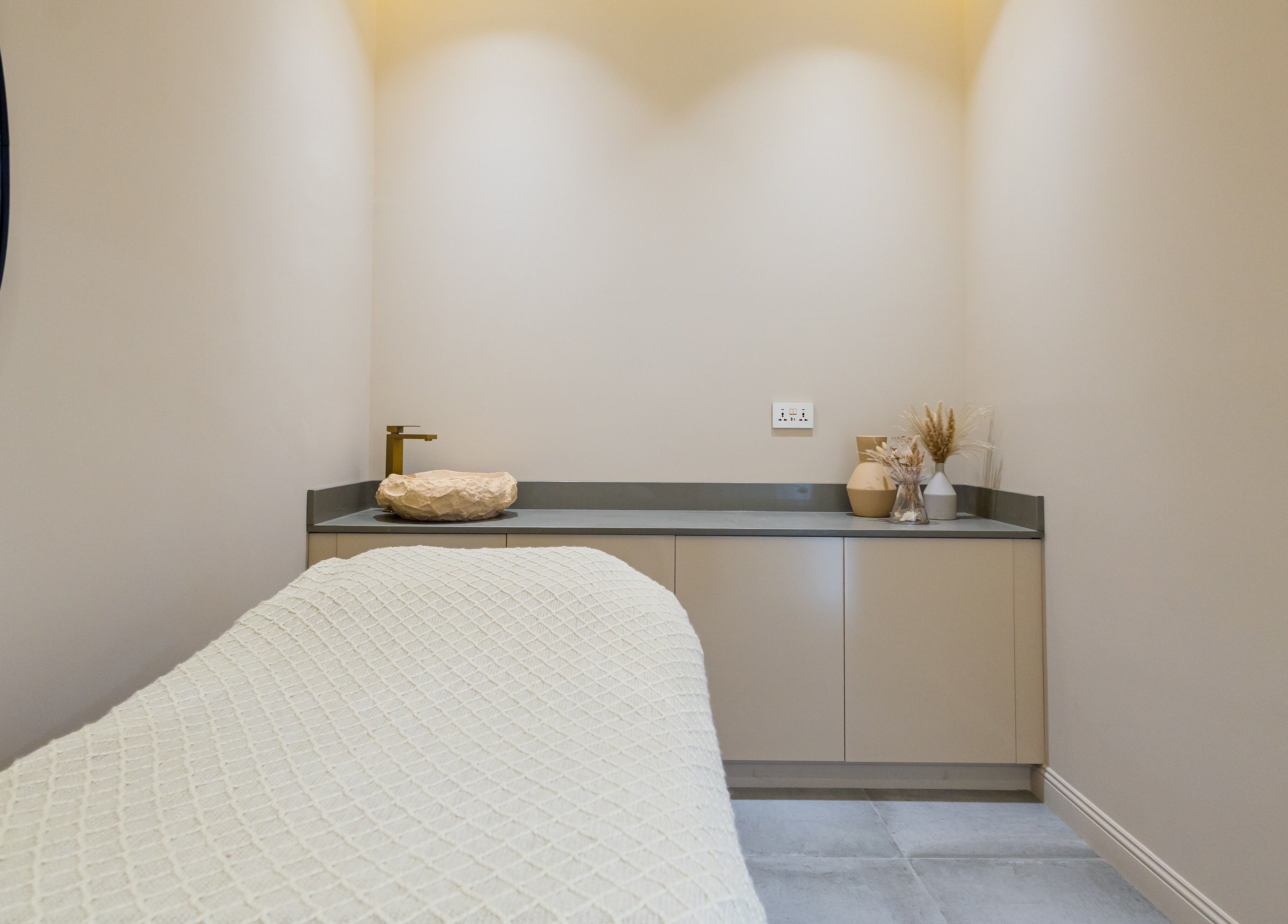 Relaxing treatment room at The Den Salon, Dubai, AE, featuring soothing neutral tones and elegant decor.