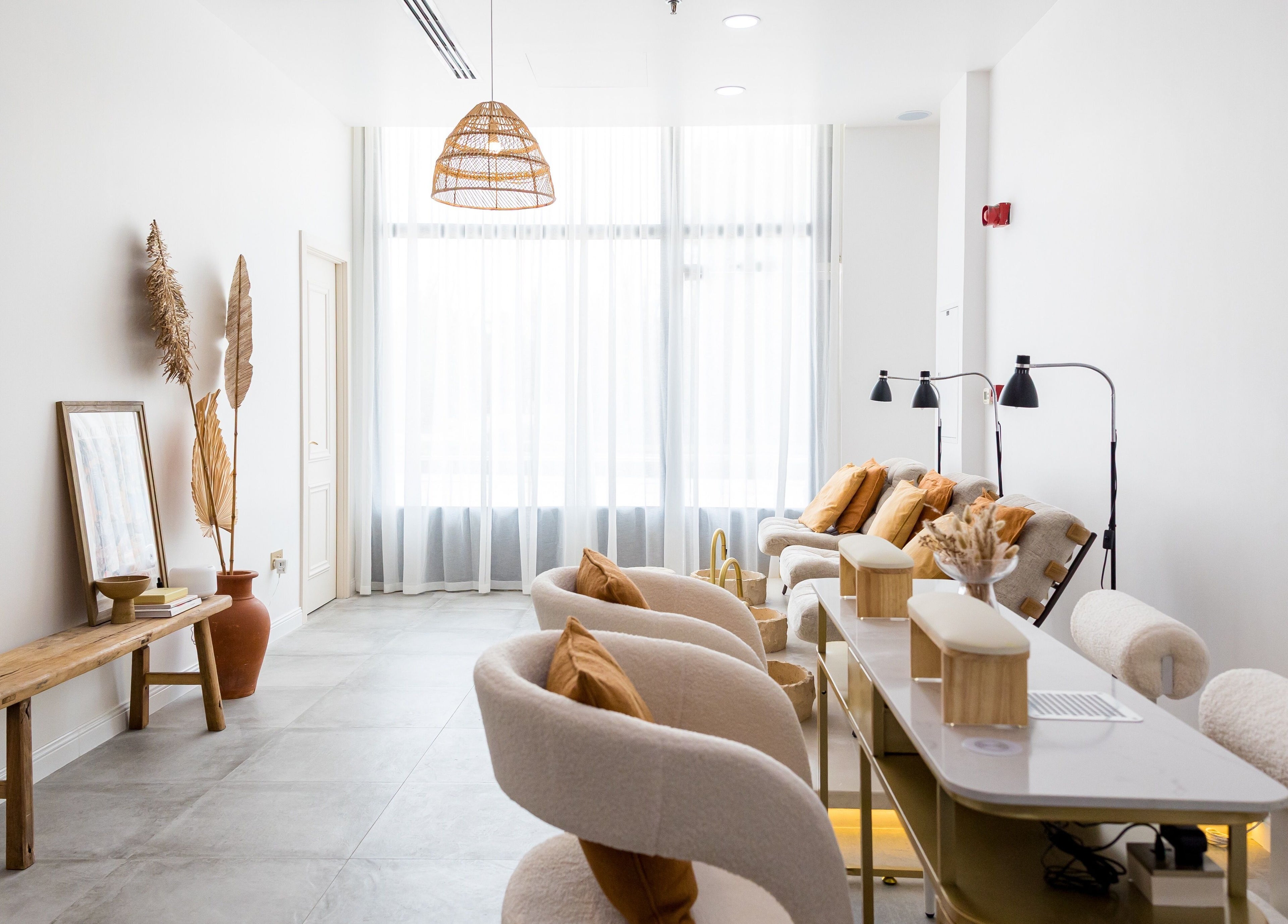 Chic and serene interior of The Den Salon, Dubai, AE, featuring plush seats and warm decor for ultimate relaxation.