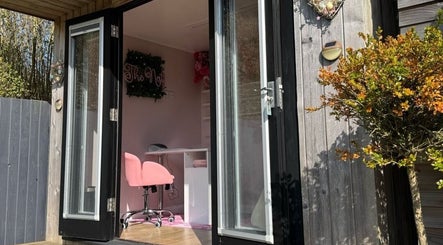 Open doors leading to The Nest's interior at Stoke-on-Trent, England, GB with pink chair and desk.