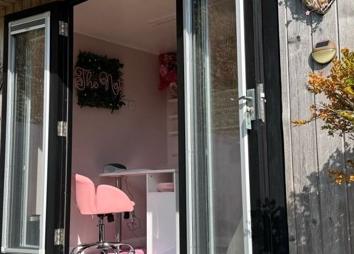 Entrance to The Nest beauty salon in Stoke-on-Trent, England, GB featuring a stylish pink chair.