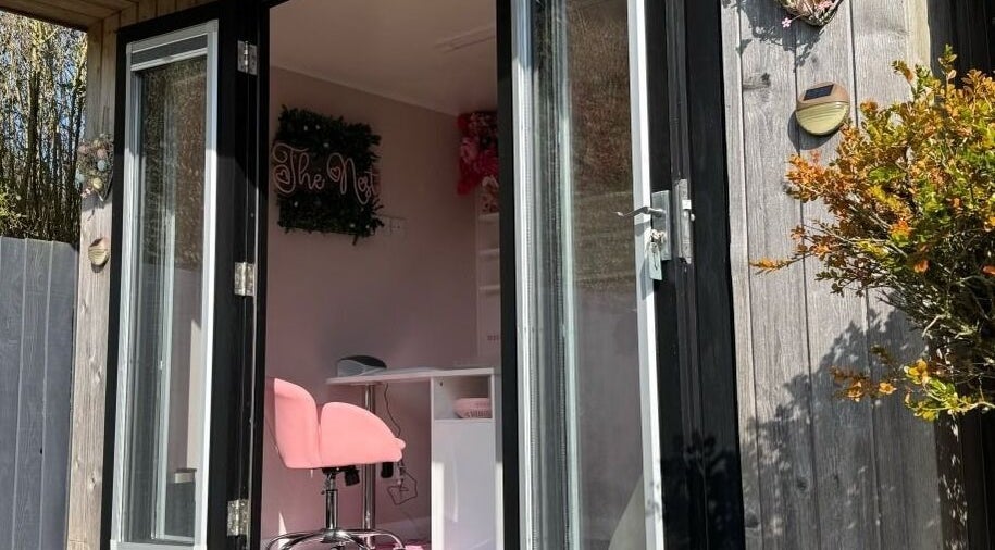 Entrance to The Nest beauty salon in Stoke-on-Trent, England, GB featuring a stylish pink chair.