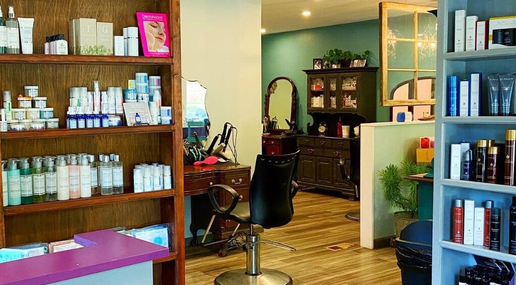 Elegant salon interior at The Avenue, Lakewood, New York, US showcasing product shelves and styling area.