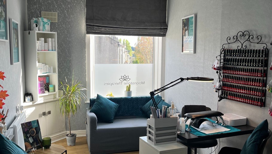 Tranquil therapy room at Moonstone Therapies, Brighouse, England, with cozy seating and nail care setup.
