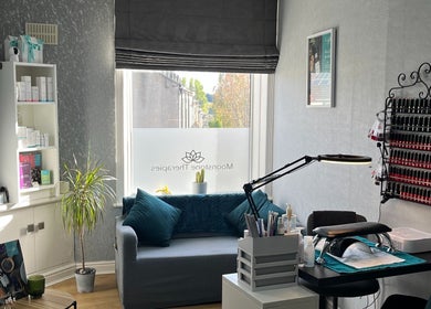 Tranquil therapy room at Moonstone Therapies, Brighouse, England, with cozy seating and nail care setup.
