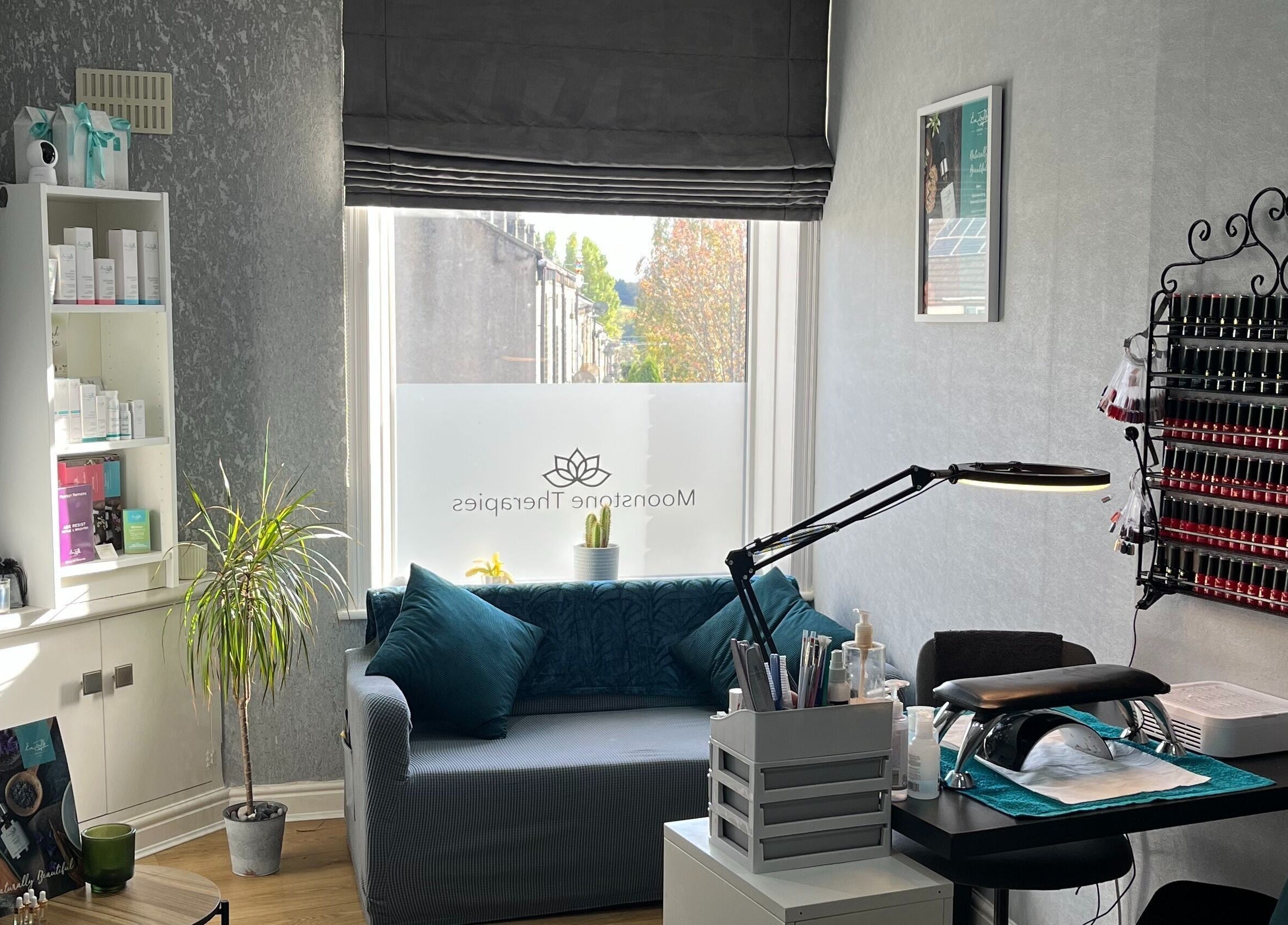 Tranquil therapy room at Moonstone Therapies, Brighouse, England, with cozy seating and nail care setup.