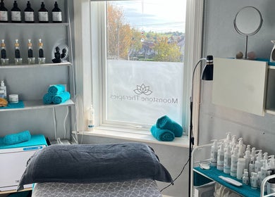 Cozy treatment room at Moonstone Therapies in Brighouse, England, GB, showcasing skincare products and turquoise towels.