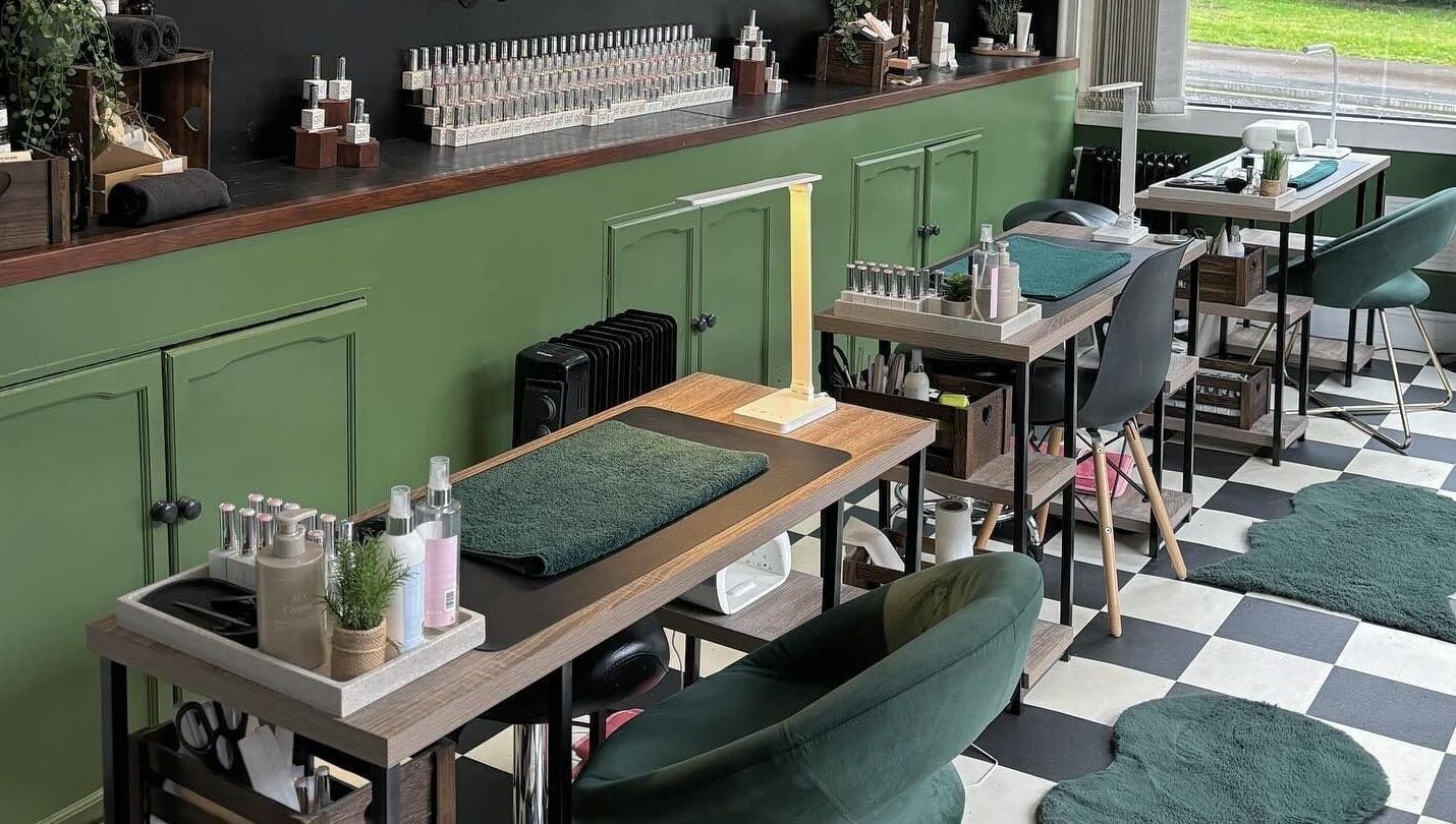 Cozy interior of Station Beauty nail salon in Whitehill, England, GB, featuring stylish manicure stations and decor.