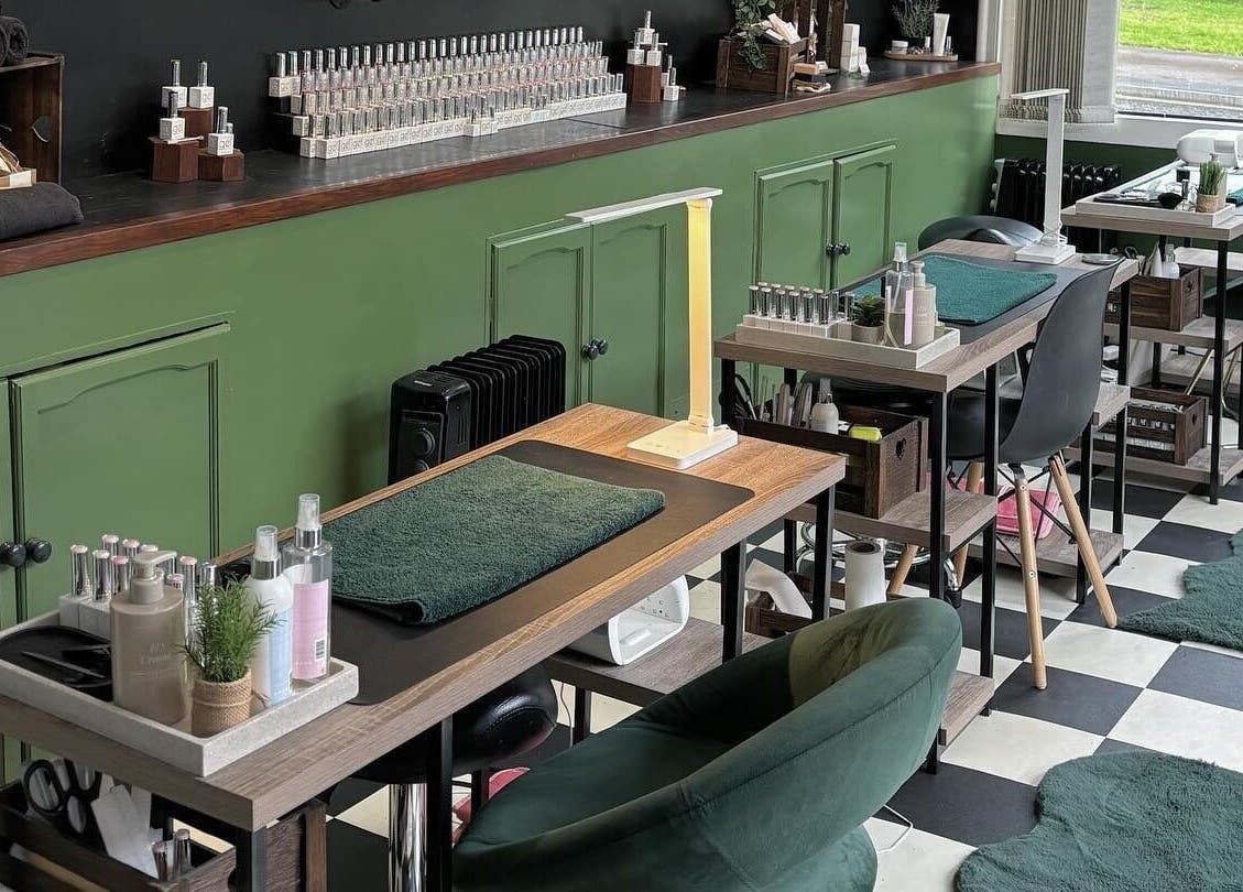 Cozy interior of Station Beauty nail salon in Whitehill, England, GB, featuring stylish manicure stations and decor.