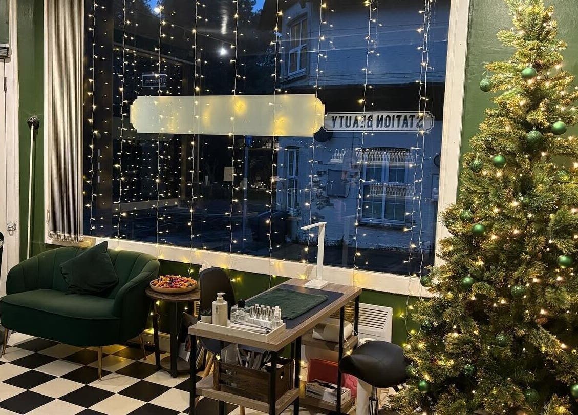 Inviting interior of Station Beauty in Whitehill, England, GB with festive lights and cozy seating.