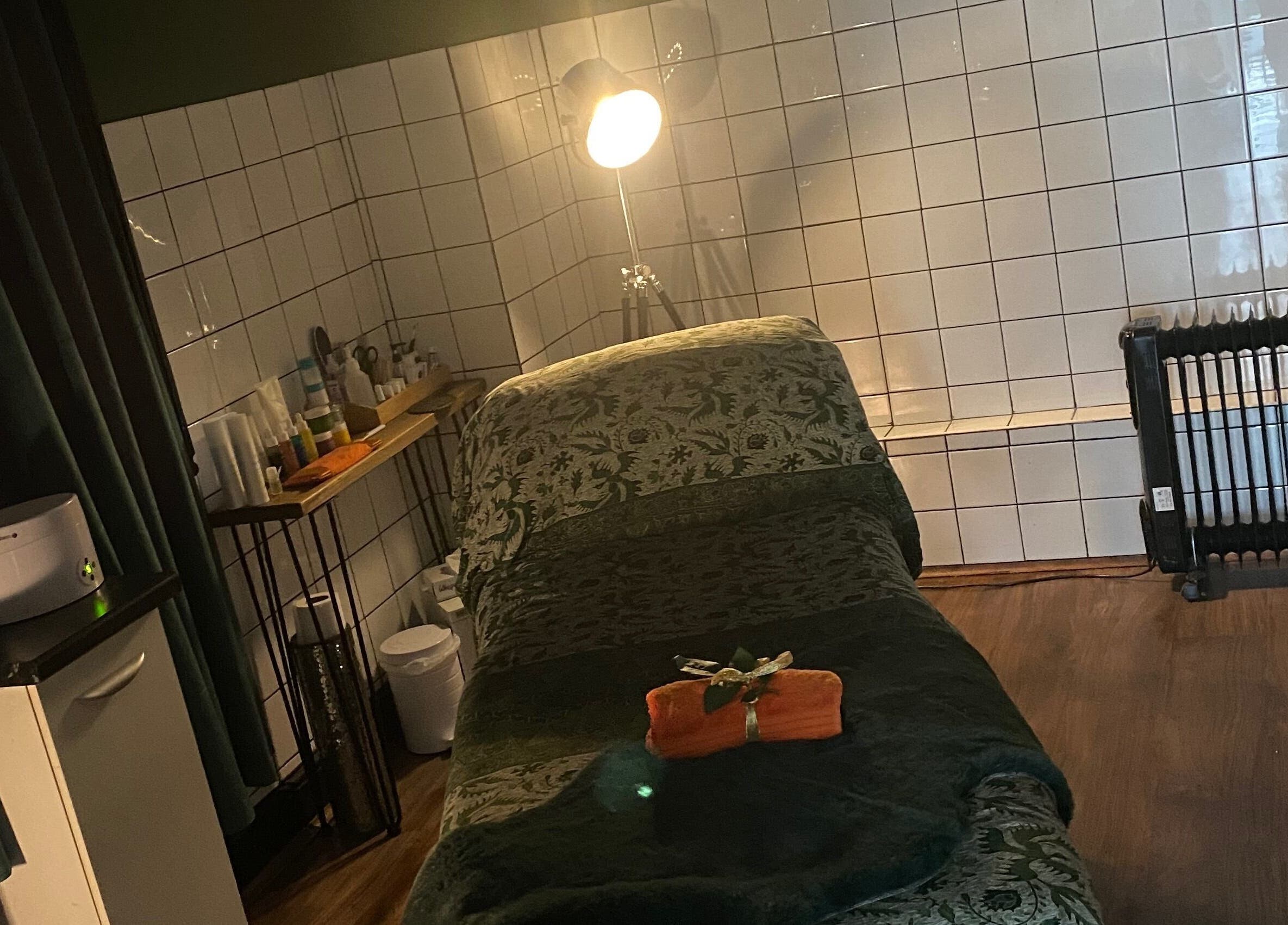 Serene treatment room at Station Beauty in Whitehill, England, GB, featuring a plush therapy bed and ambient lighting.