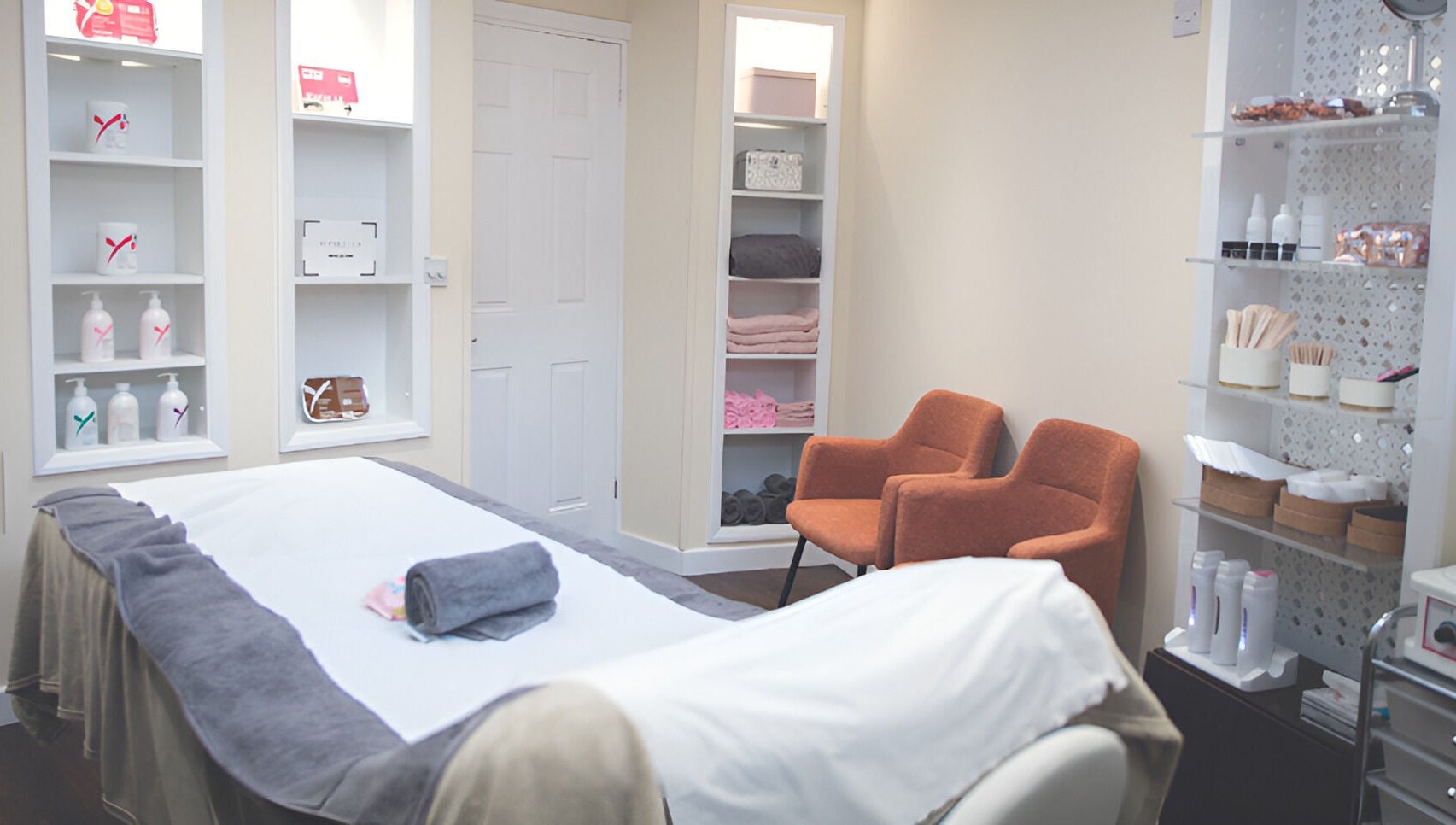 Relaxing treatment room at WAX & GLO in Penarth, Wales, GB with a cozy massage table and elegant decor.