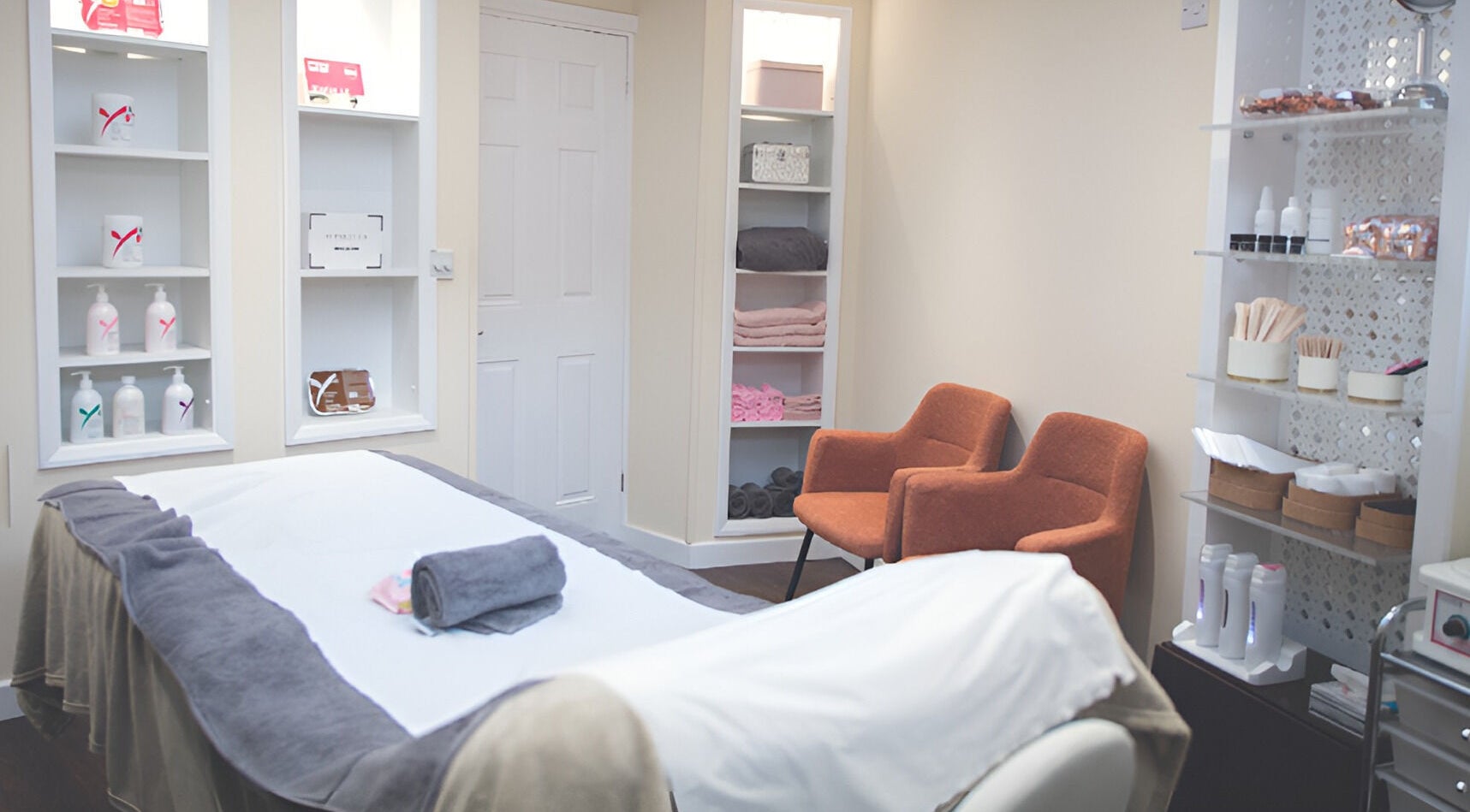 Relaxing treatment room at WAX & GLO in Penarth, Wales, GB with a cozy massage table and elegant decor.