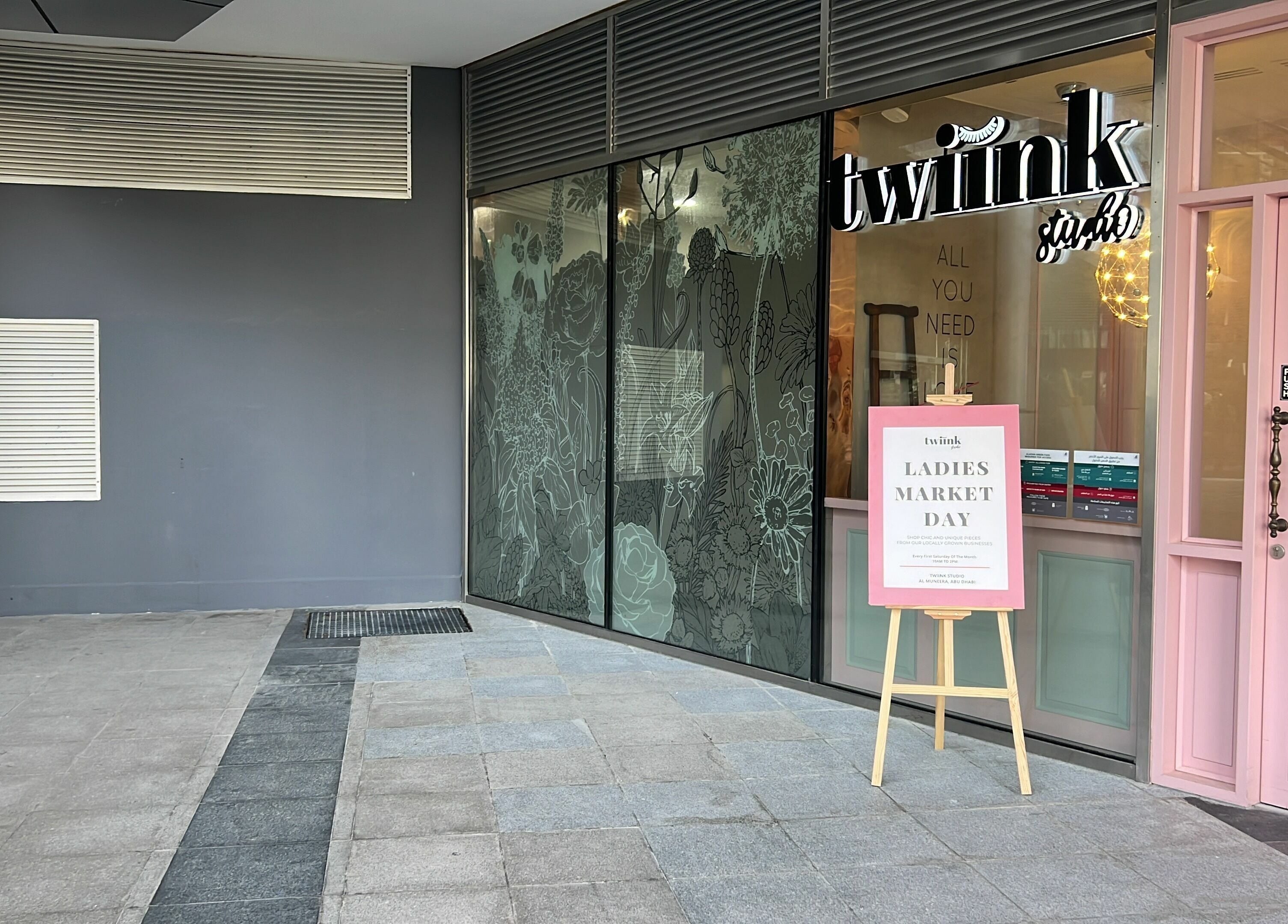 Entrance of Twiink Studio in Abu Dhabi, AE, showcasing event sign and floral decor.