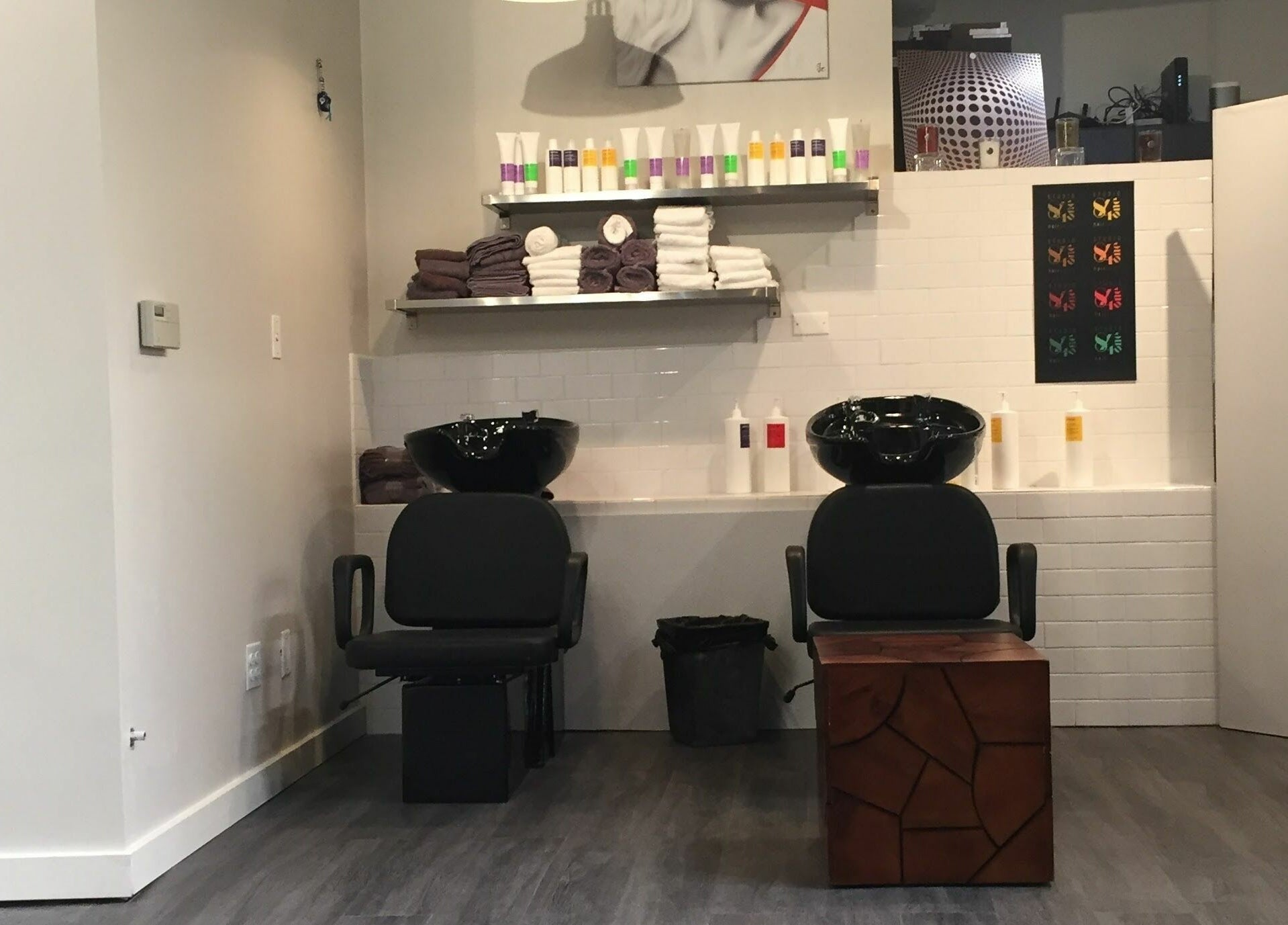 Modern hair wash station at Studio 84one in Chicago, Illinois, US, featuring sleek chairs and shelving.