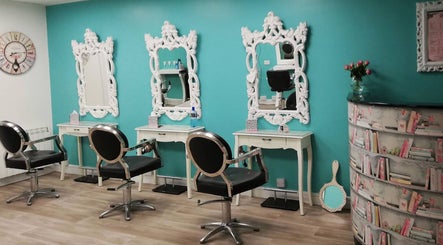 Elegant styling chairs and mirrors at Riah Hairdressing, Donegal, County Donegal, IE with vibrant blue walls.
