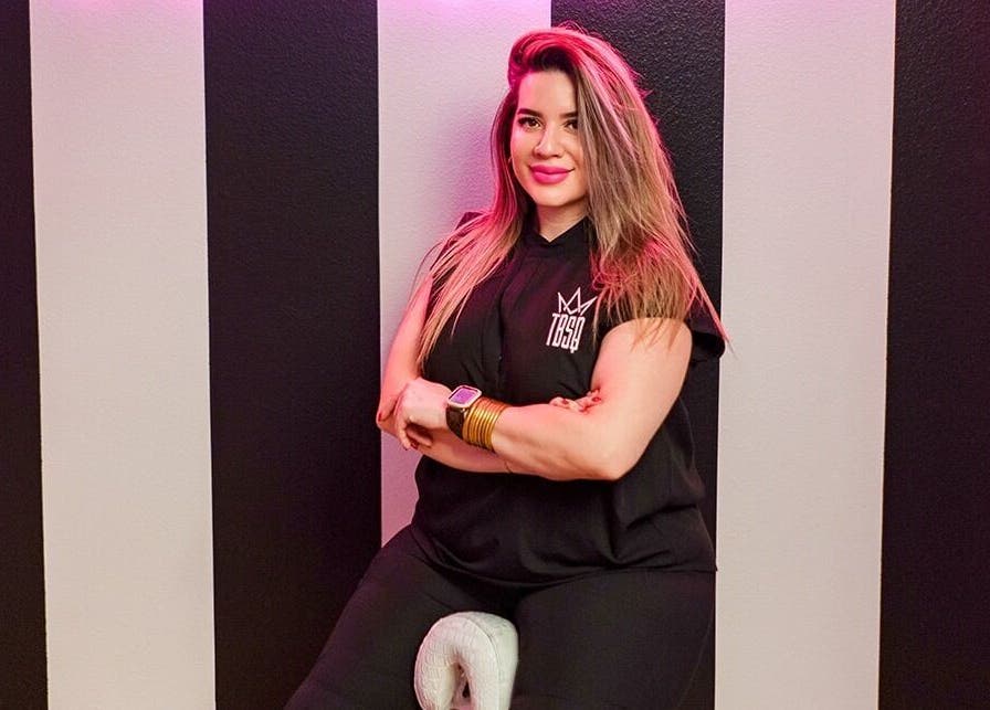 Woman with long hair at The Brow Shaping Queen, Frisco, Texas, US posing against striped wall.