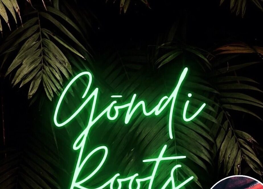 Neon sign of Gōndi Roots Salon LTD amidst lush greenery in Cardiff, Wales, GB.