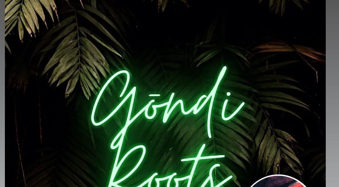 Neon sign of Gōndi Roots Salon LTD amidst lush greenery in Cardiff, Wales, GB.