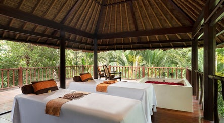Relaxing spa beds and tub at Kayumanis Spa Ubud, Bali, Bali, ID surrounded by lush greenery.