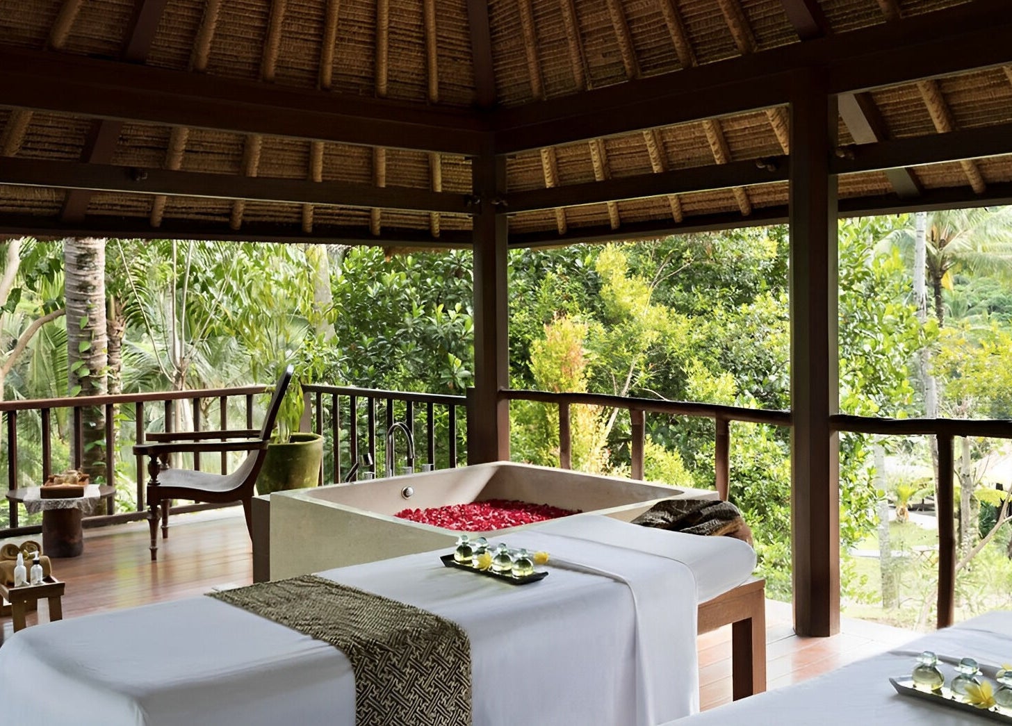 Luxurious spa bed and bath overlooking lush foliage at Kayumanis Spa Ubud, Bali, Bali, ID.