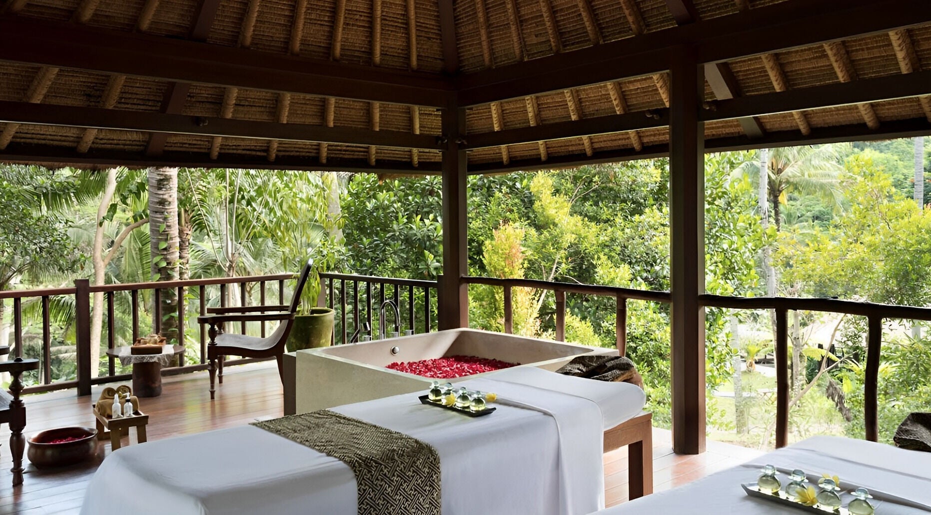 Luxurious spa bed and bath overlooking lush foliage at Kayumanis Spa Ubud, Bali, Bali, ID.