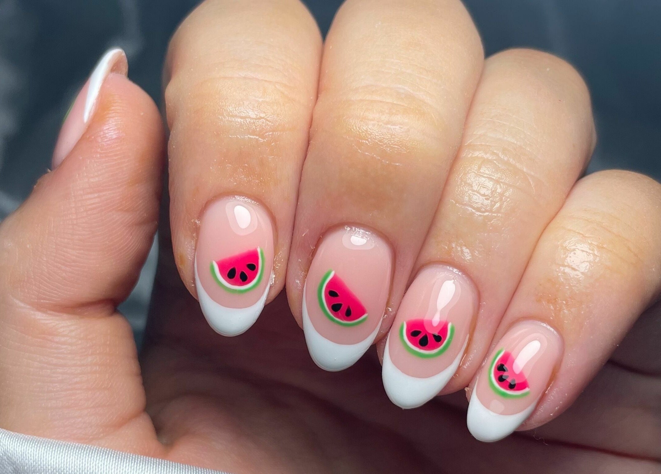 Hand adorned with watermelon nail art at That Nail Studio, Handforth, England, GB.