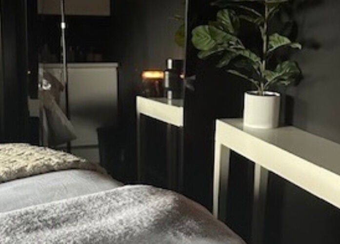 Calming therapy room at Dr Heather Muir Aesthetics & Skin, Uddingston, Scotland, GB with cozy bed and ambient lighting.