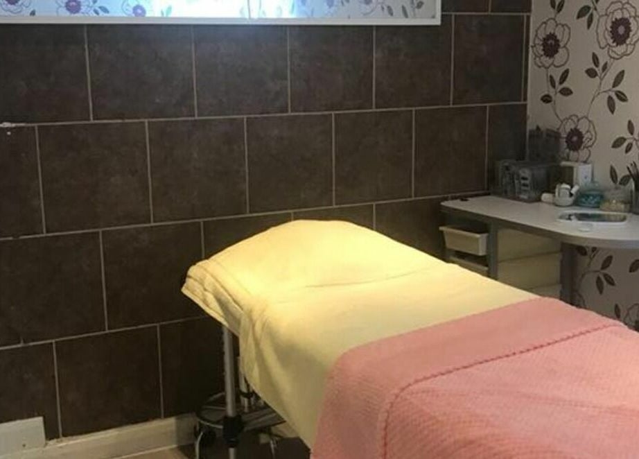 Cozy treatment room at Broadway Beauty, Southend-on-Sea, England, GB featuring a massage table and floral decor.