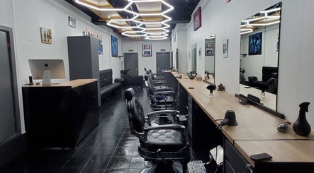 Modern interior of Sauchiehall Barbers, Glasgow, Scotland, GB, featuring sleek black chairs and stylish decor.