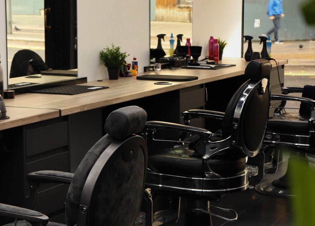 Modern barber chairs at Sauchiehall Barbers, Glasgow, Scotland, GB, offering a stylish haircut experience.