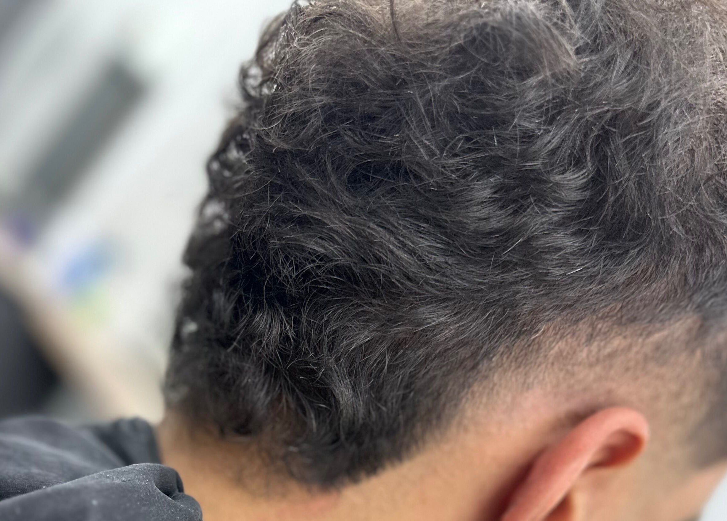 Close-up of a trendy haircut at Sauchiehall Barbers in Glasgow, Scotland, GB, showcasing textured curls.