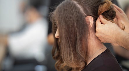 Stylist perfecting a hairstyle at Arelis Beauty Salon, Orlando, Florida, US. Close-up of skilled hands.