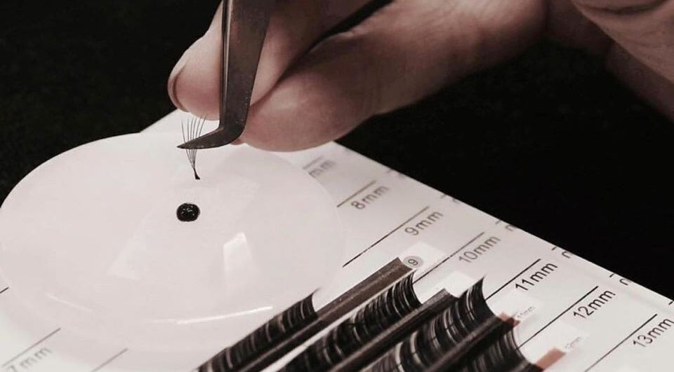 Close-up of lash extensions at Laura at Elite Beauty, Peterborough, England, GB. Tweezers and lash grid visible.