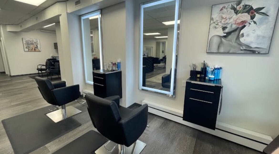 Modern styling stations at Salon Femia in Somerville, Massachusetts, US with sleek black chairs and mirrors.