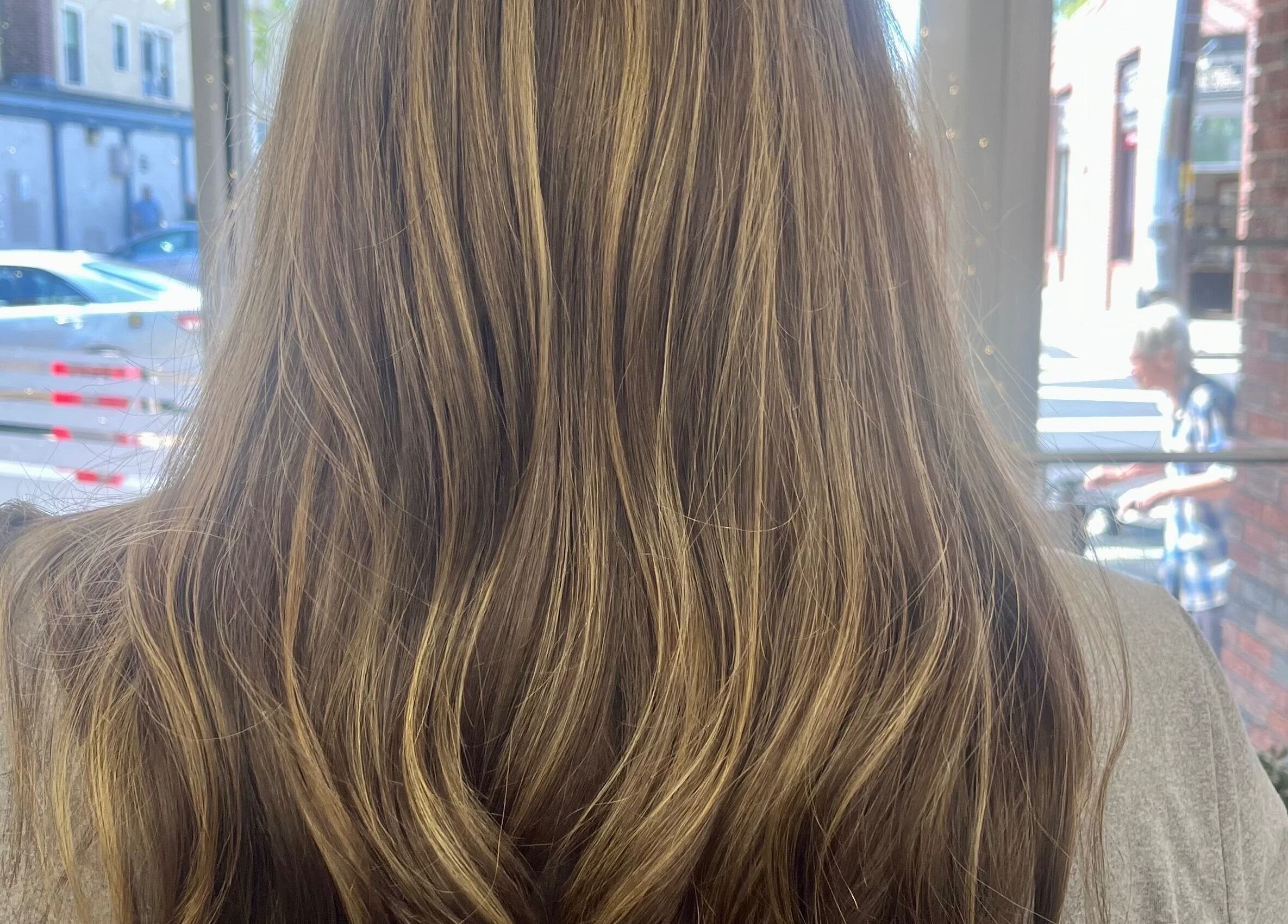 Beautiful wavy hair styled at Salon Femia in Somerville, Massachusetts, US, reflecting natural golden highlights.