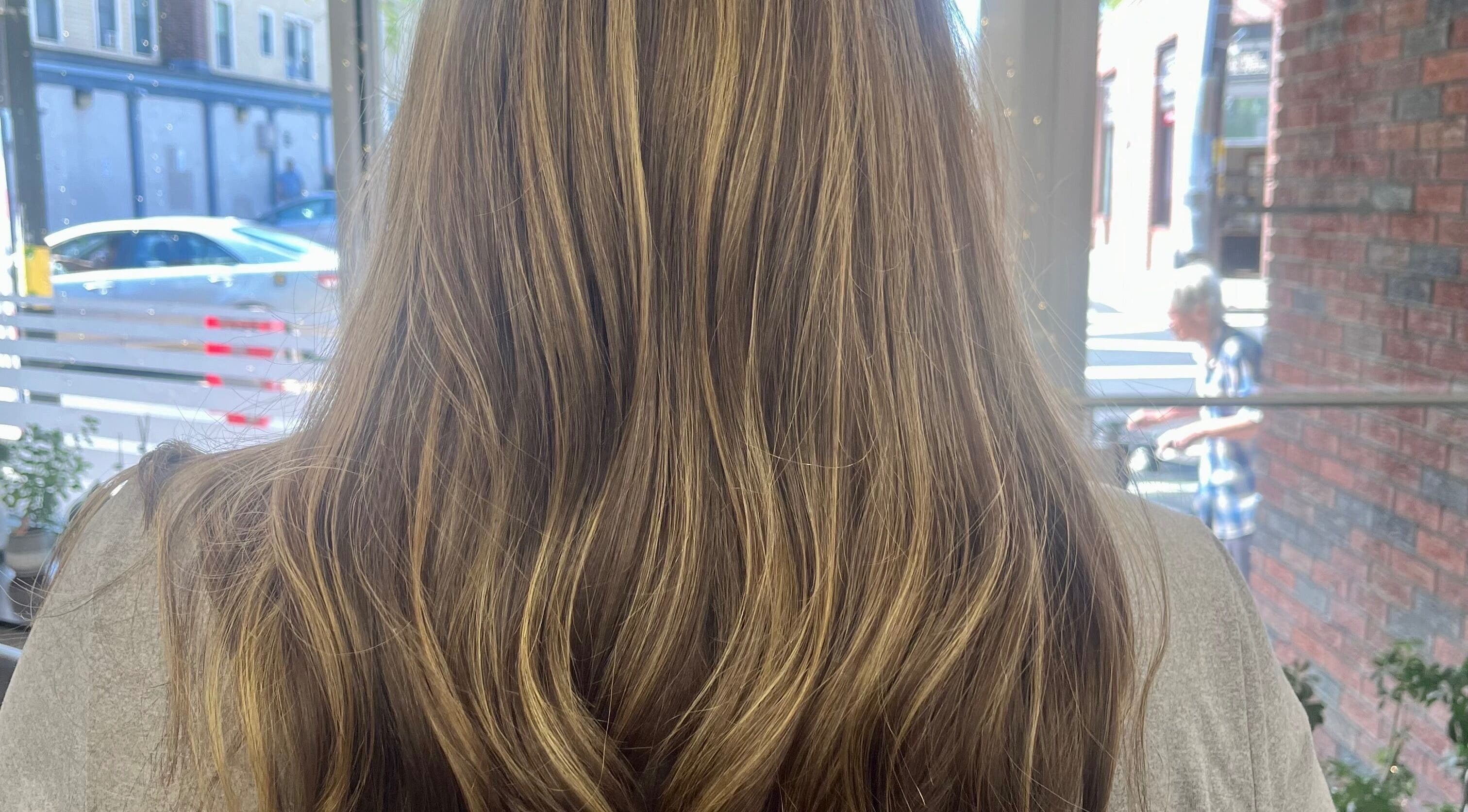 Beautiful wavy hair styled at Salon Femia in Somerville, Massachusetts, US, reflecting natural golden highlights.