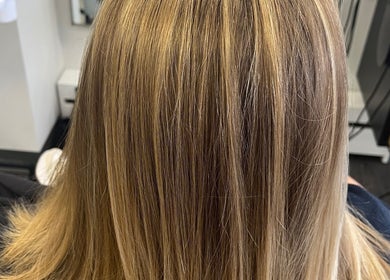 Smooth blonde hair treatment at Salon Femia, Somerville, Massachusetts, US, showcasing radiant highlights.