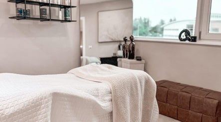 Elegant treatment room at The Glow Clinic, Cardiff Bay, GB featuring a relaxing massage bed and decor.