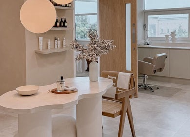 Bright, modern interior of The Glow Clinic in Cardiff Bay, GB, featuring a stylish chair and elegant decor.