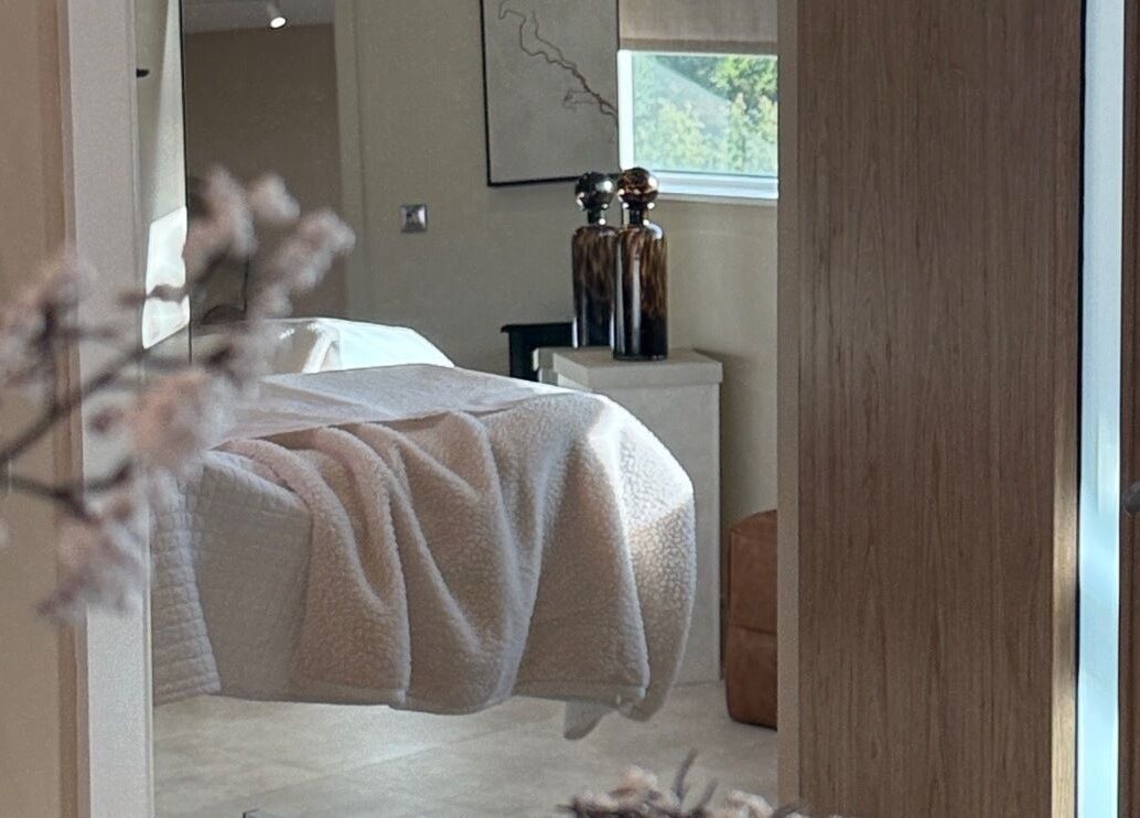 Cozy treatment room at The Glow Clinic, Cardiff Bay, GB with soft lighting and elegant decor.