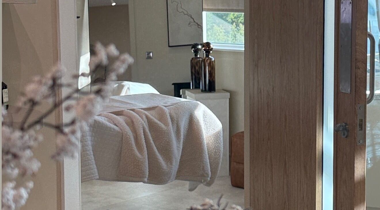 Cozy treatment room at The Glow Clinic, Cardiff Bay, GB with soft lighting and elegant decor.