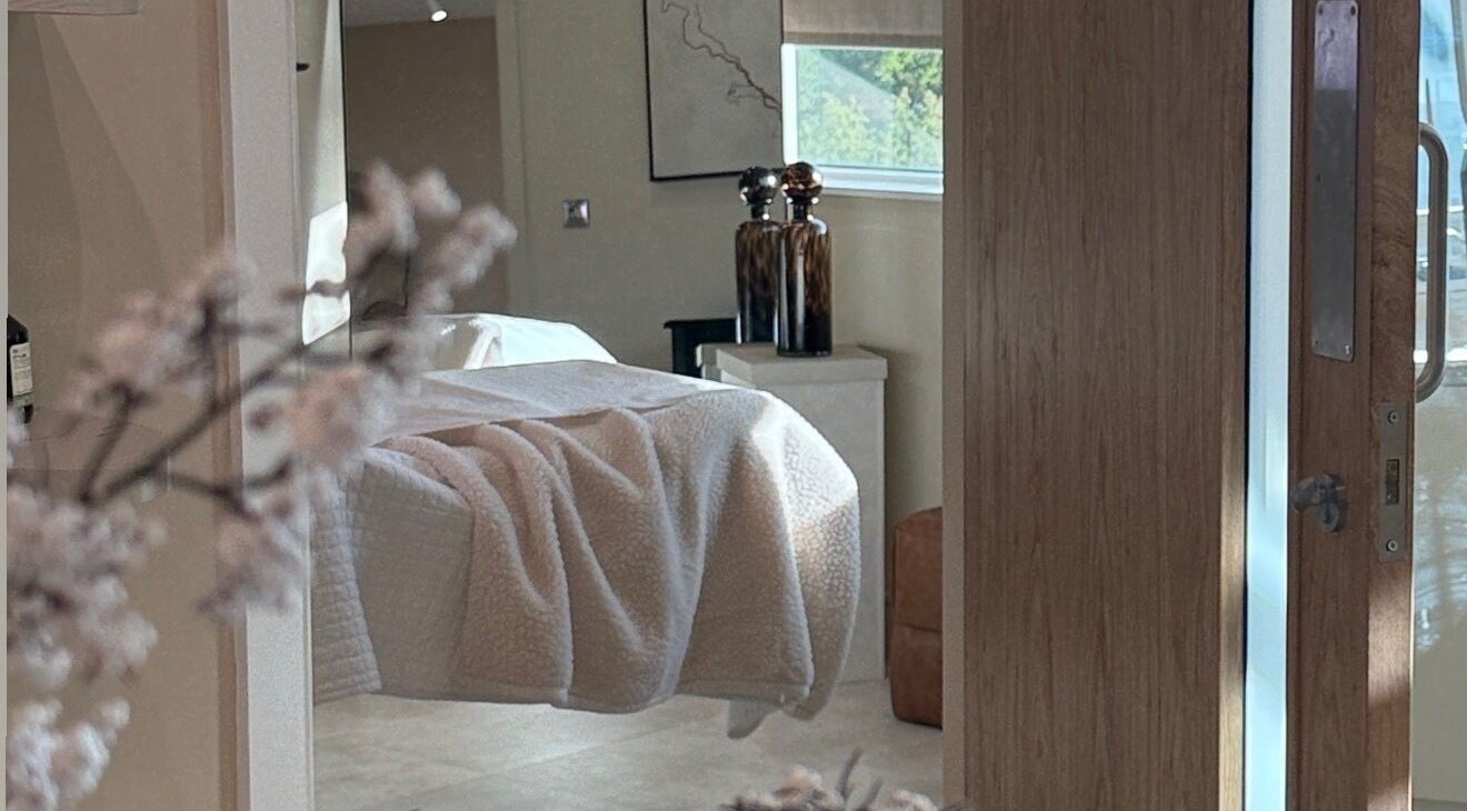 Cozy treatment room at The Glow Clinic, Cardiff Bay, GB with soft lighting and elegant decor.